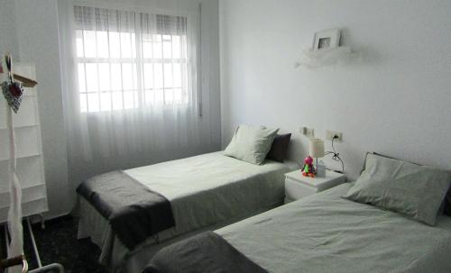 1 dormitorio con 2 camas y ventana en La Casa de Maribel, en Priego de Córdoba