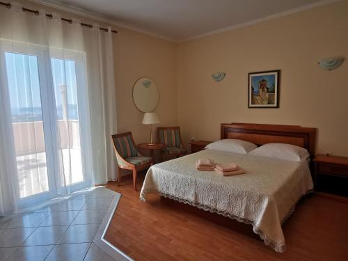 ein Schlafzimmer mit einem Bett und einem großen Fenster in der Unterkunft House Smajić in Dubrovnik