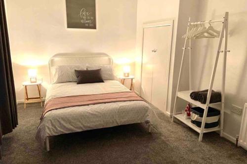 ein Schlafzimmer mit einem weißen Bett und einem Schrank in der Unterkunft Flat 5 EIA House in Belfast
