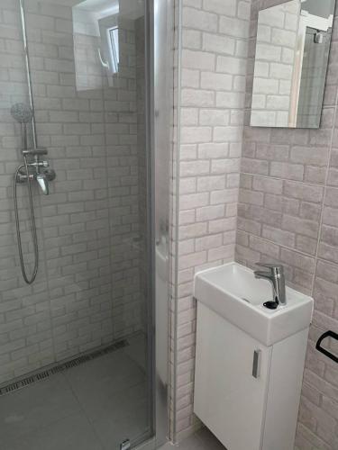 a white bathroom with a shower and a sink at Ubytovanie MI - TATRY in Kravany