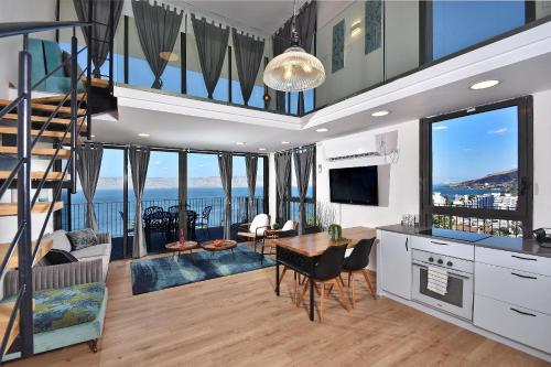 a kitchen and living room with a view of the ocean at YalaRent La Mera- Suits Hotel with Sea of Galilee views in Tiberias