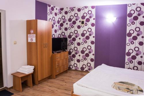 1 dormitorio con 1 cama, armario y TV en къща Славяни, en Tryavna