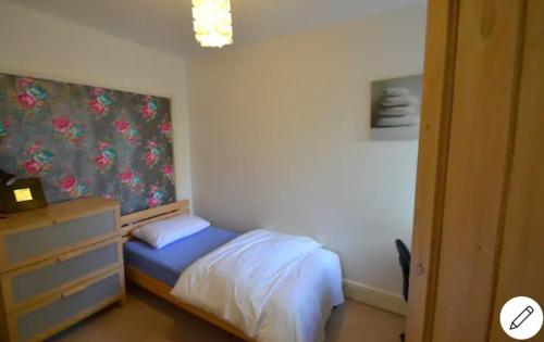 a small bedroom with a bed and a dresser at Palm House -Complete Holiday HOME IN SOUTHSEA in Portsmouth