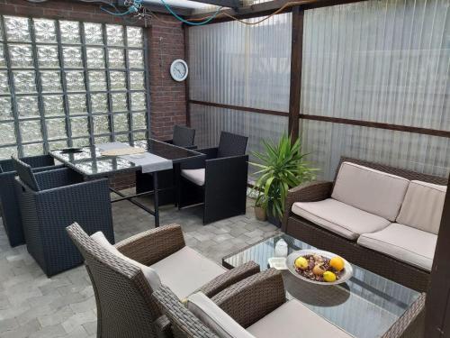 un patio con sillas y una mesa con un bol de fruta en Haus Leonora, en Cuxhaven