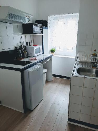 a small kitchen with a sink and a microwave at STUDIOS MAGUI in Ax-les-Thermes