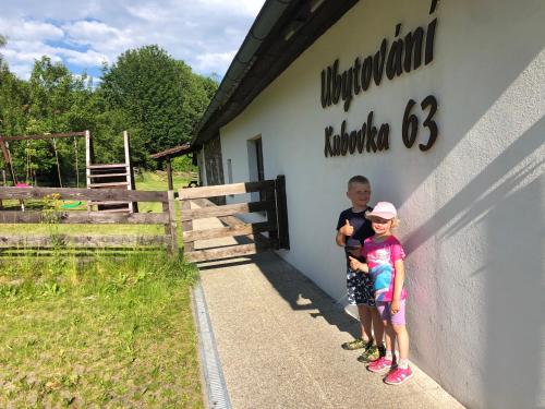 dos niños parados frente a un edificio en Kubovka 63, en Kubova Huť