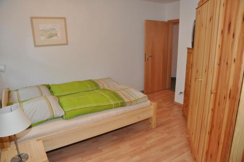 Un dormitorio con una cama con mantas verdes. en Ferienwohnung Naurod, en Wiesbaden