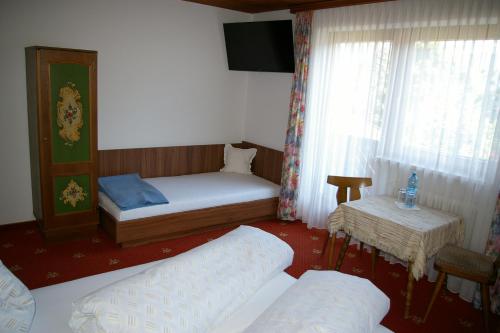 ein kleines Schlafzimmer mit einem Bett und einem Fenster in der Unterkunft Haus Sonja in Finkenberg