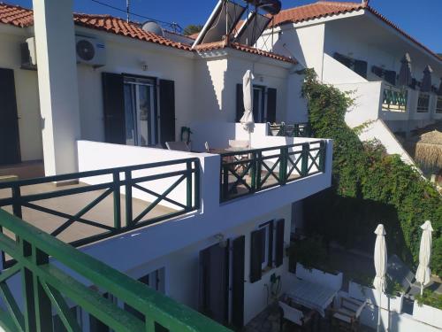 a white house with a balcony with a fence at Armenistis View Studios in Armenistis