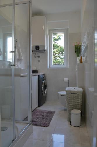 a bathroom with a shower and a toilet and a window at Apartment Seven in Split