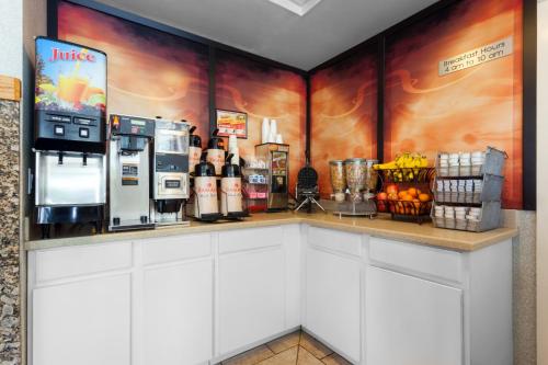 a coffee shop with a counter with drinks and food at Ramada by Wyndham SeaTac Airport North in Tukwila