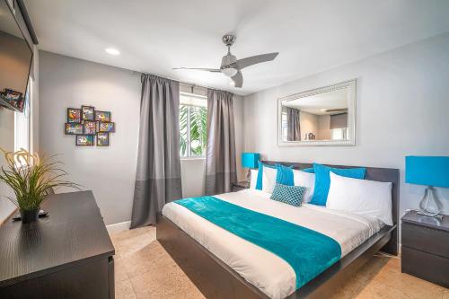 Schlafzimmer mit einem Kingsize-Bett mit blauen Akzenten in der Unterkunft Fountain condo 2 story Pool BBQ Balcony in Miami Beach
