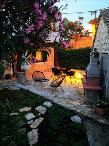 a patio with a table and chairs and a fire place at Holiday Home Little Heaven in Slatine