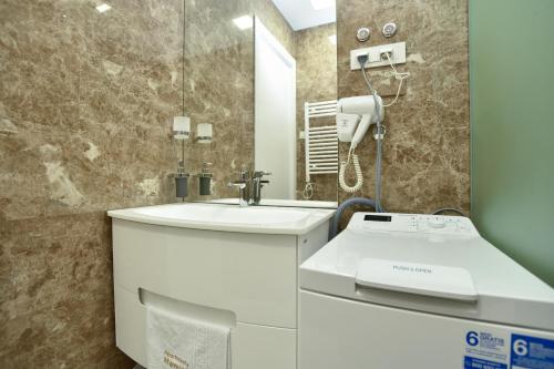 a bathroom with a sink and a phone at Apartments Menuet in Budva