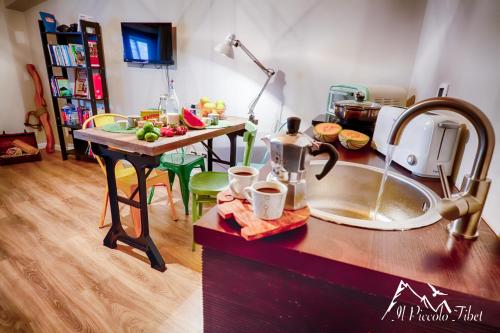 a kitchen with a counter with a sink and a table at Il Piccolo Tibet - Gran Sasso in LʼAquila