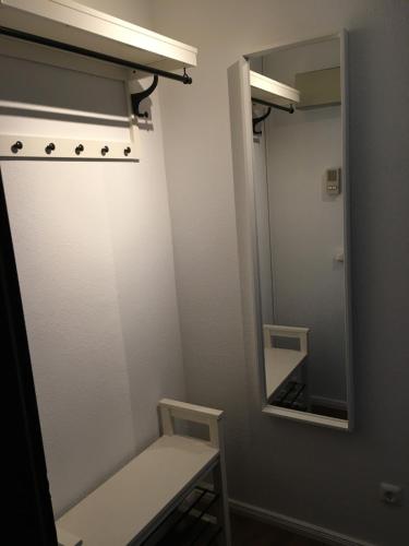 a small bathroom with a mirror and a bench at Apartment 9, OG 23 in Schleswig