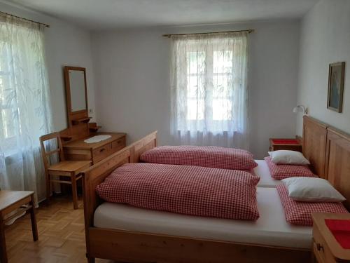 a bedroom with three beds and a mirror and windows at Haus Thoma in Stelvio