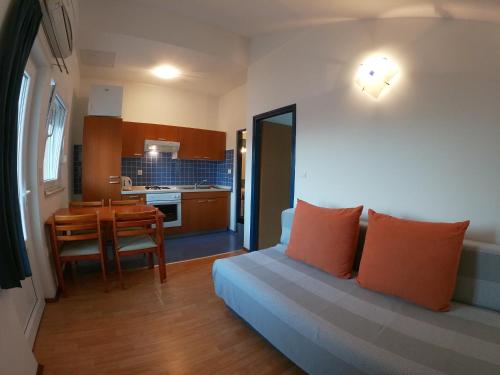 a living room with a couch and a kitchen with a table at Apartments Nikolina in Posedarje