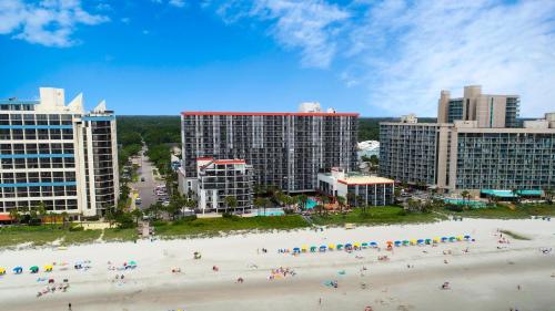 a group of people on a beach in front of buildings at Grande Cayman Resort in Myrtle Beach