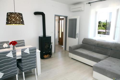 a living room with a couch and a stove at Pure nature coastal apartment VLASTA in Ankaran
