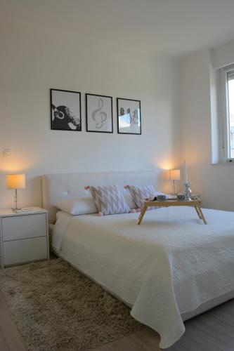 a white bedroom with a bed with a table on it at Apartment Seven in Split