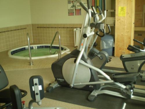 a gym with a treadmill and a bath tub at Homestead Inn in Wolf Point