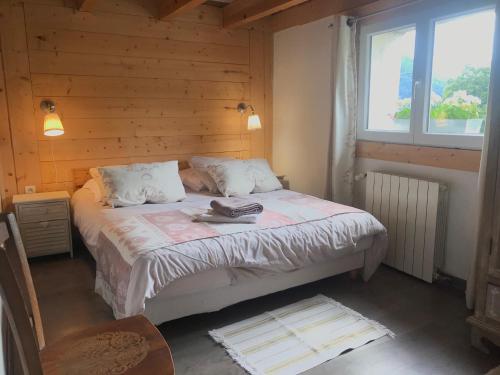 ein Schlafzimmer mit einem Bett mit einer Holzwand in der Unterkunft Chez Julie in Thollon