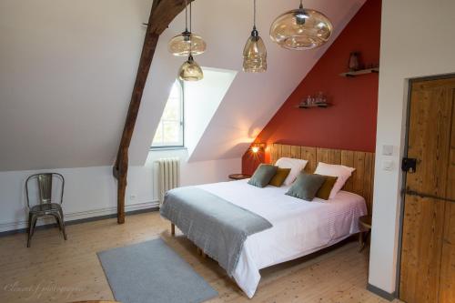 a bedroom with a white bed and a red wall at Au Souffle de Vert in Bouvaincourt-sur-Bresle