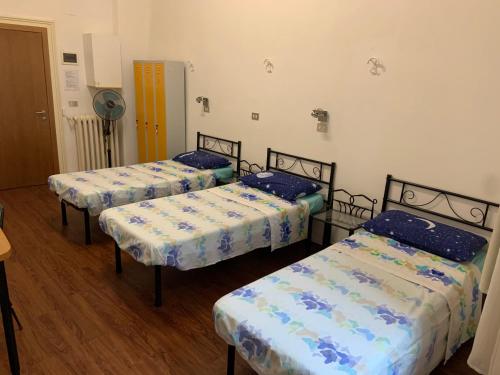 a room with three beds and a fan at Archie's House in Venice