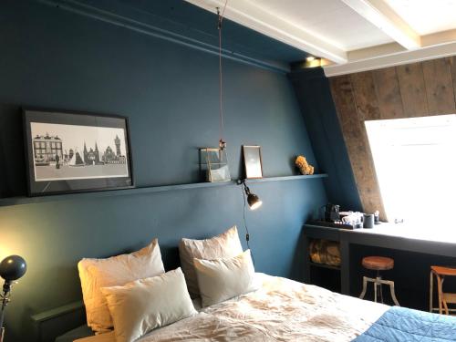 1 dormitorio con paredes azules y 1 cama con almohadas en Elfstedenstate Friesland, en Easterein