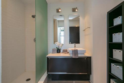a bathroom with a sink and a mirror at Mid Century Modern Downtown Condo 30+ Night Min in Nashville
