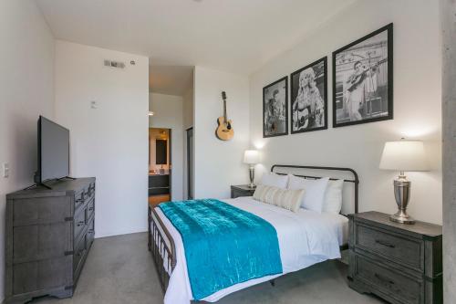 a bedroom with a bed and a flat screen tv at Mid Century Modern Downtown Condo 30+ Night Min in Nashville