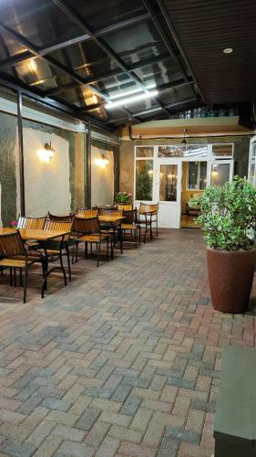 アドレルにあるRuzanna Innのパティオ(テーブル、椅子、鉢植えの植物付)