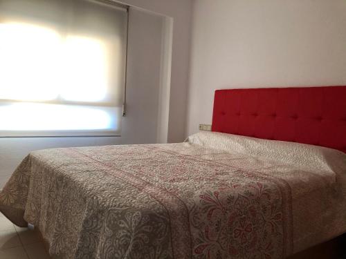 a bedroom with a bed with a red headboard and a window at Miraplaya in Benicàssim