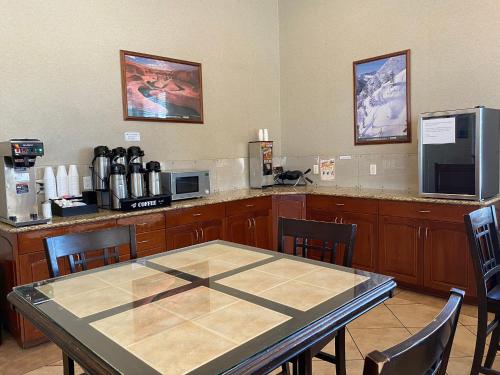 een keuken met een tafel en een aanrecht met een magnetron bij National 9 Inn Price in Price