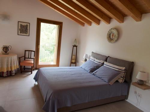 um quarto com uma cama, uma mesa e uma janela em Valle B&B em Castelgomberto