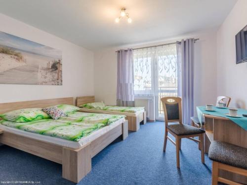 ブワディスワボボにあるPokoje gościnne AQUA-Chłapowoのベッドルーム1室(ベッド2台、デスク、テーブル付)