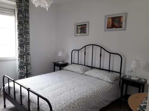 una camera con un letto e due tavoli e una finestra di "Cà di Ellen" Appartamento con deposito bici privato a Finale Ligure