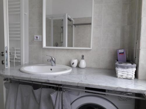 bagno con lavandino e lavatrice di "Cà di Ellen" Appartamento con deposito bici privato a Finale Ligure