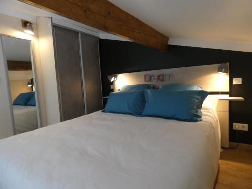 Un dormitorio con una cama blanca con almohadas azules. en L'Escale d'Aubagne, en Aubagne