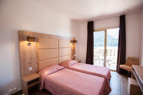 a hotel room with a bed and a dresser at Hotel Kalliste in Porto Ota