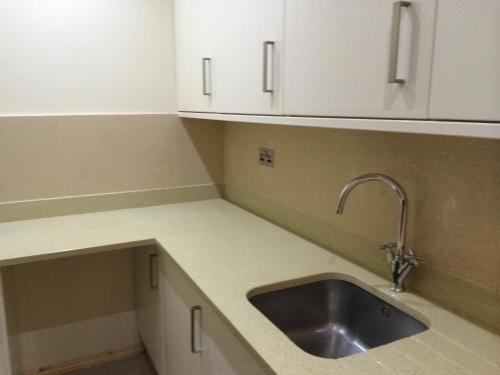 a kitchen with a sink and white cabinets at Fountain Hotel in London