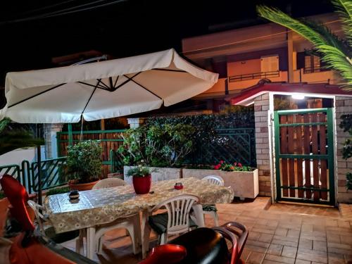 a table and chairs with an umbrella on a patio at A Casa Ta Valeria in Gallipoli