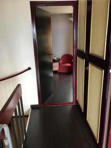 an open door leading to a living room with a red couch at La maison du lac in Lutry