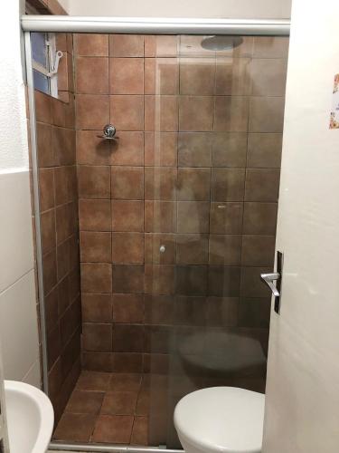 a bathroom with a shower with a toilet and a sink at Hotel Pousada Mato Grosso in Campo Grande