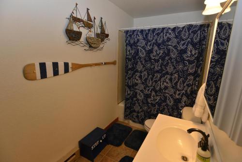 a bathroom with a sink and a surfboard on the wall at The Park Chalet by Casago McCall - Donerightmanagement in McCall