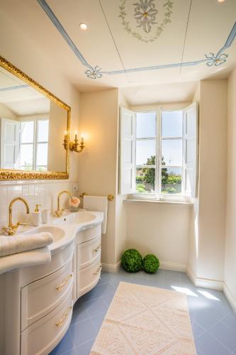 a bathroom with two sinks and a mirror at Villa La Preziosa in Lucca
