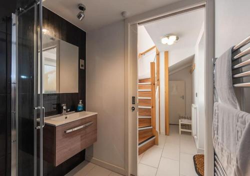 a bathroom with a sink and a shower with a mirror at The Old Net Store - Cosy Anstruther Studio Flat in Cellardyke