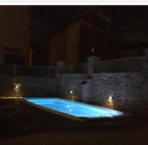 Tuscany House of Artist في مونتينيوزو: حوض استحمام ساخن أزرق في جدار حجري في الليل
