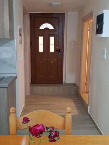 a room with a door and a table with roses at Fyllou Apartment Asprovalta in Asprovalta
